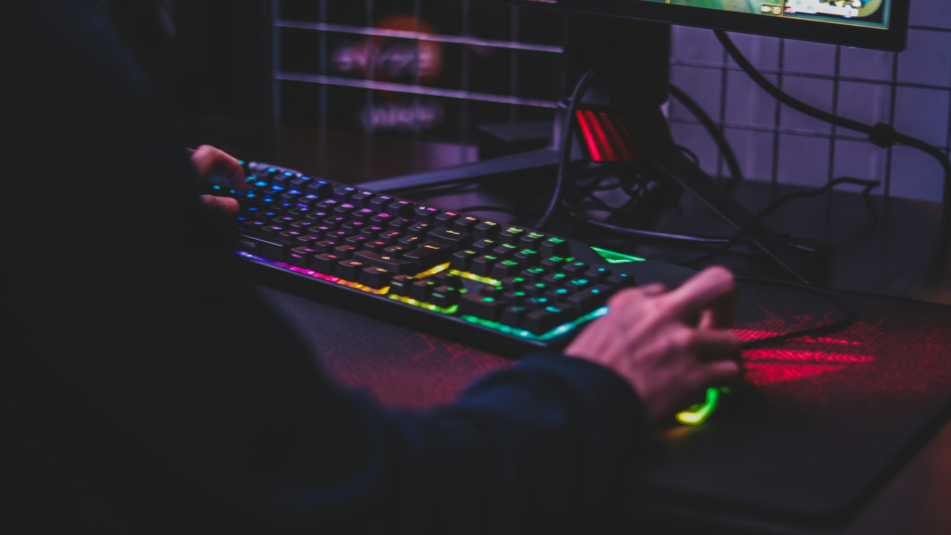 Backlit gaming desk setup at dusk